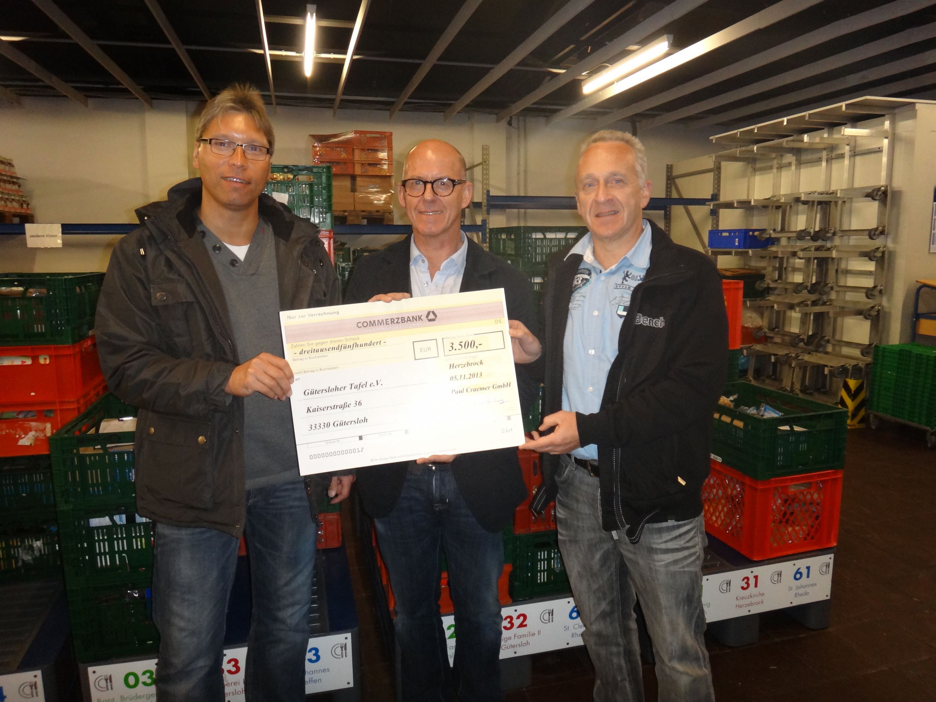 Scheckübergabe im Zentrallager der Gütersloher Tafel: Craemer-Betriebsrat Ralf Timmer (links) und Marathonspezialist Werner Goldkuhle (rechts), mit Tafel-Geschäftsführer Hans-Jürgen Trendelkamp