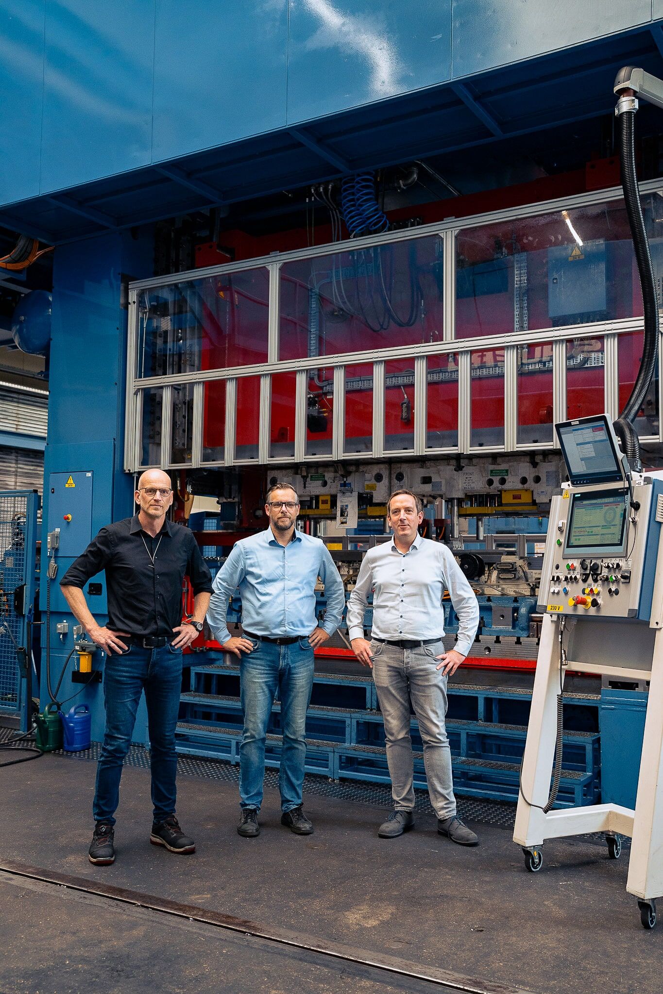 Guido Schneider, Michael Gericke und Thomas Burholt vor der neuen Servopresse