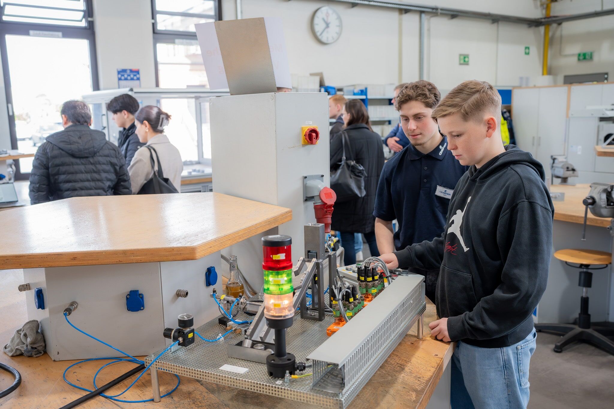 Sortieren Metallscheiben: Abdurrahman Catakli, Mechatroniker-Azubi im 2. Lehrjahr (2.v.r.) und Sam Klüsener. Der Schüler gab direkt seine Bewerbung für ein Praktikum ab. Foto: Craemer Gruppe