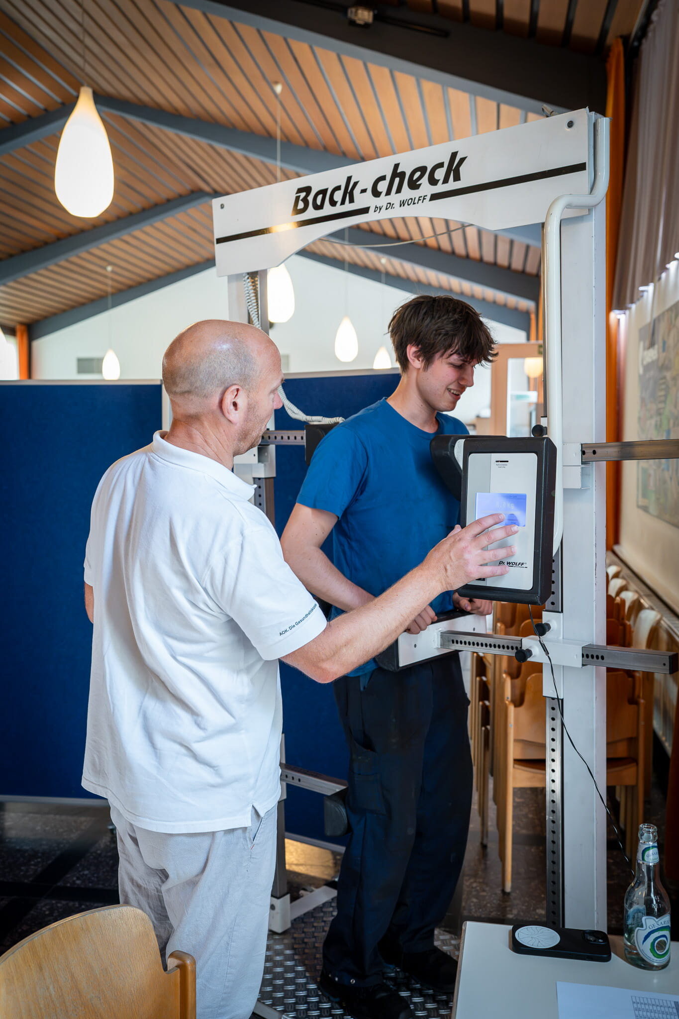 Steffen Rau (r.) testet beim Craemer Gesundheitstag seine Rückenmuskulatur im Back-Check-Messgerät. Physiotherapeut Thorsten Wagner begleitet die Analyse.