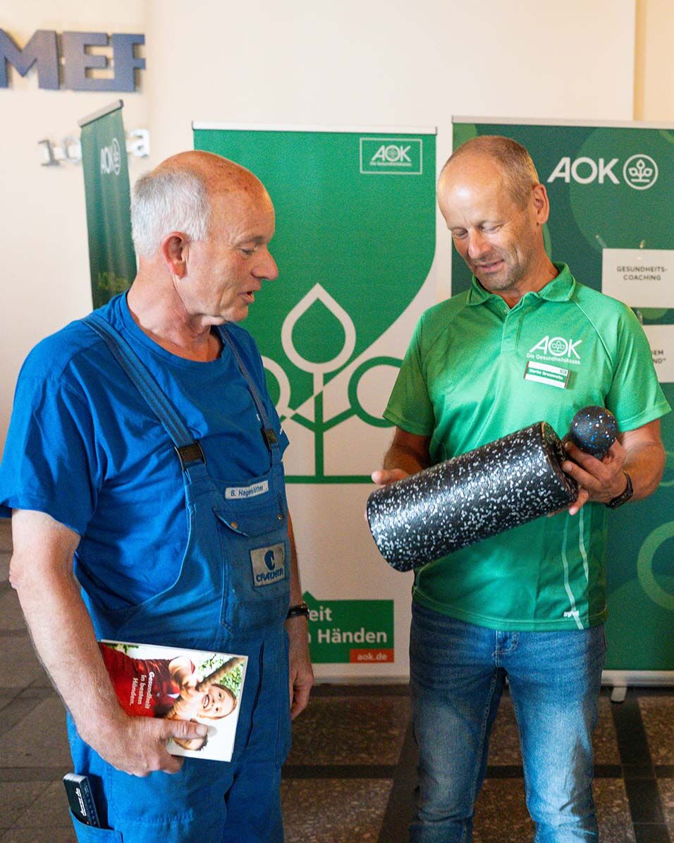 Physiotherapeut Martin Brummelte (r.) zeigt Bernhard Hagenkötter, wie sich verspannte Muskeln mit einer Massagerolle lockern lassen. 