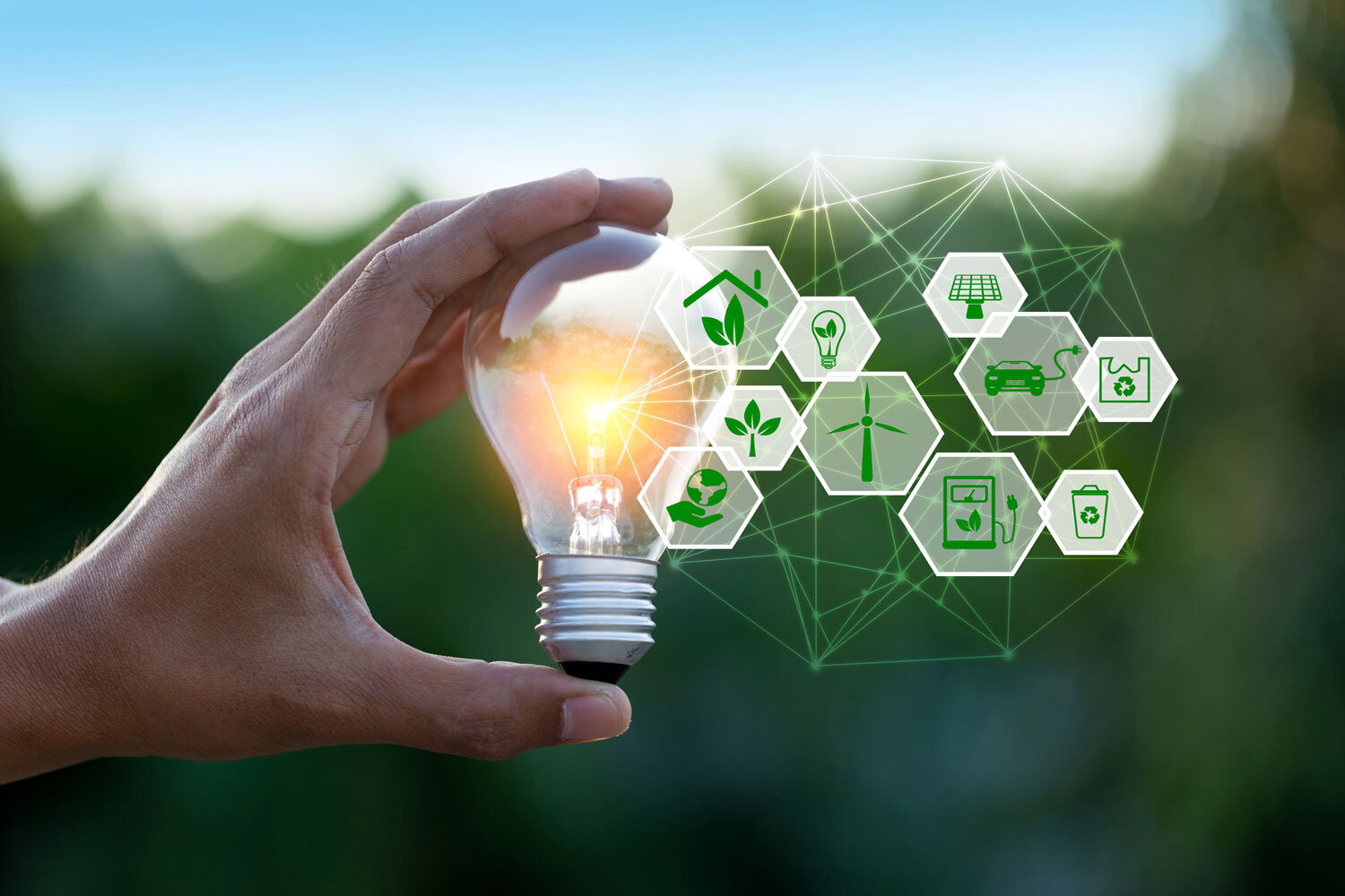 Hand holds illuminated light bulb and icons