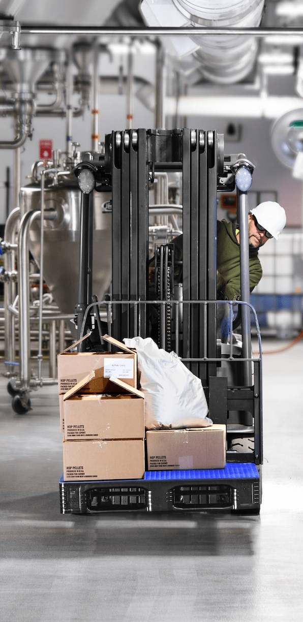 TC loaded with boxes and a white sack on a forklift truck